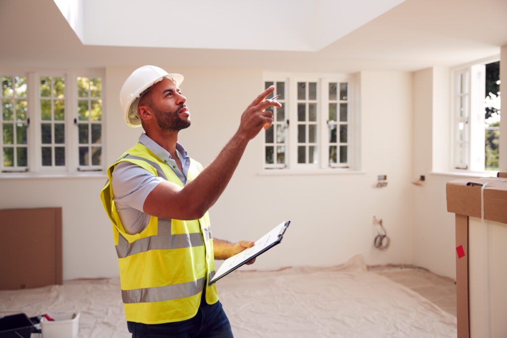Building inspector and property surveyor inspecting a house for sale and estimating repair costs